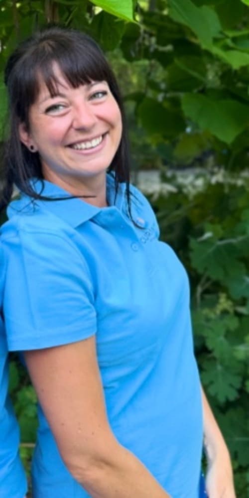 Portaitbild von Frau Günther Ein Portaitbild von Frau Günther in Curaneo T-Shirt. Sie hat langes schwarzes Haar und einen Pony.