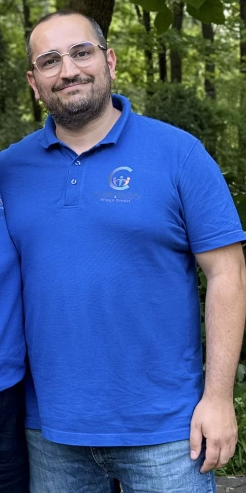 Portaitbild von Herrn Er Ein Portaitbild von Herrn Er in Curaneo T-Shirt. Er hat schwarzes kurzes Haar und Bart und trägt eine Brille.