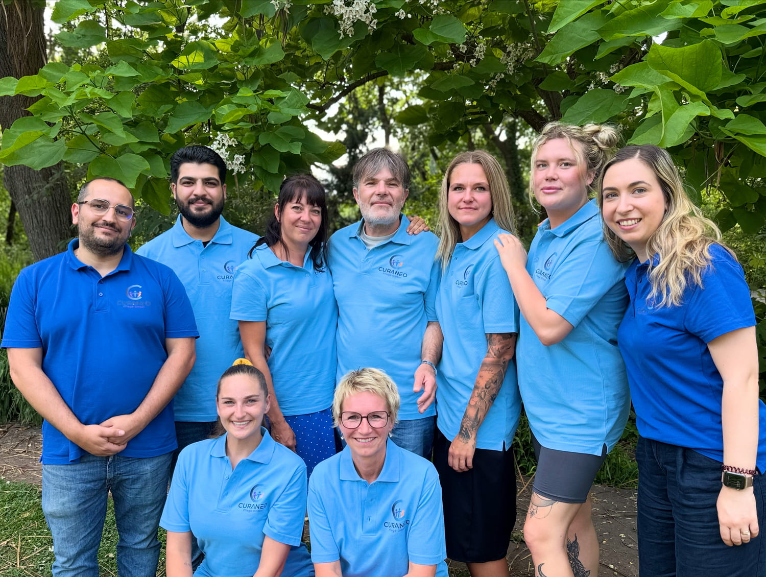 Das gesamte Curaneo Team Das gesamte Curaneo Team posiert für eine Gruppenaufnahme.