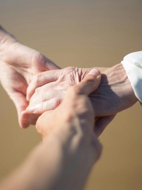 Pflege mit Herz, Respekt und Würde Drei Hände halten sich gegenseitig fest und symbolisieren Zusammenhalt.